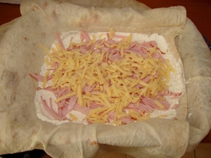 2. Выкладываем поверх соуса творожную массу, солим и перчим ее по вкусу. Наверх - порезанные соломкой или натертые на крупной терке ветчина и половина сыра.