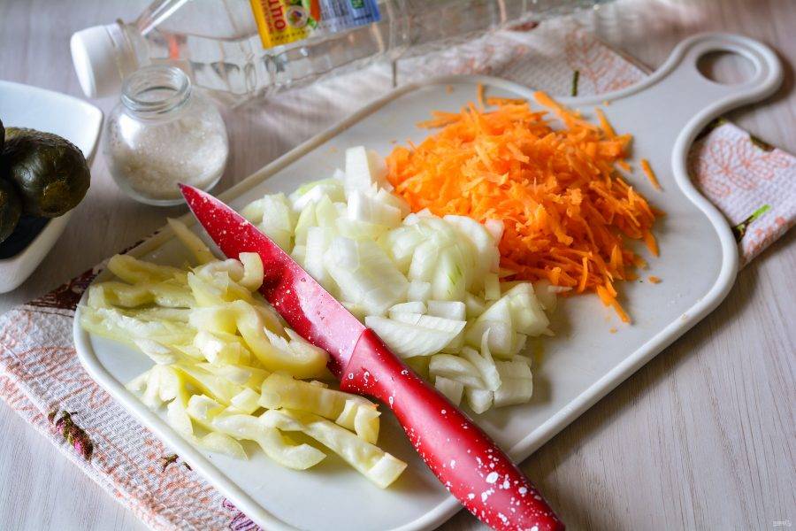 Свежие овощи почистите и измельчите. Лук нарежьте кубиками, морковку натрите на терке, а перец нарежьте полосками.