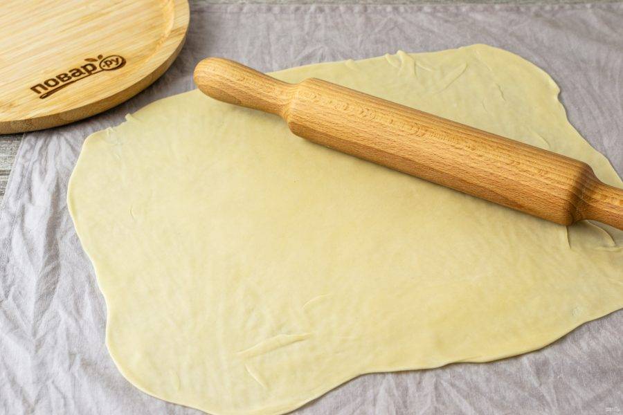 Тесто раскатайте максимально тонко, придайте ему форму прямоугольника и переложите на влажное кухонное полотенце.
