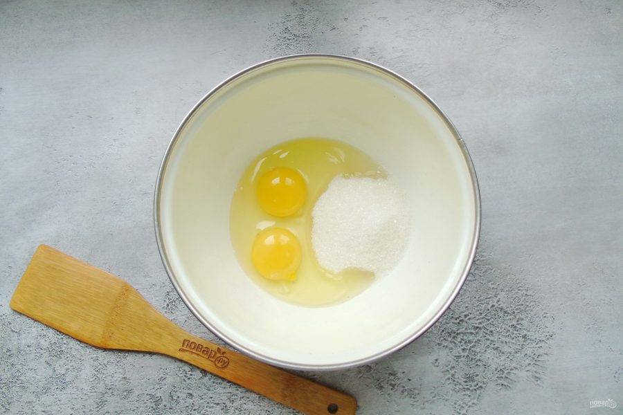 В миску разбейте яйца и всыпьте обычный сахар и ванильный.