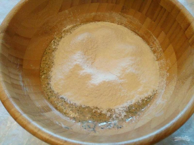 Тщательно соедините компоненты ложкой, а затем порциями при просеивании всыпьте смесь белой пшеничной муки (для начала возьмите 100 грамм) и разрыхлителя. 