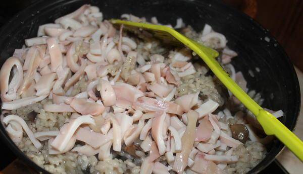 Кальмары остудите, мелко нарежьте. Когда рис почти готов, добавляем кальмары, соль и перец. Все перемешиваем.