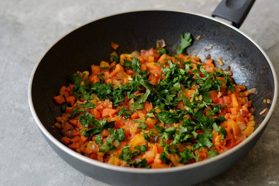 Измельчите помидоры, добавьте к обжаренным овощам. Потушите пару минут. В конце добавьте мелко порубленную петрушку. 