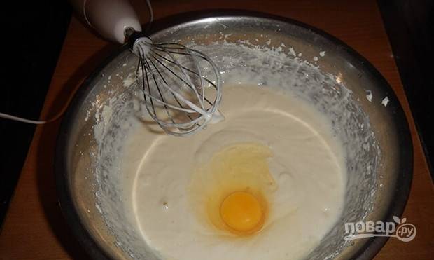 Добавьте сметану и вбейте сырое куриное яйцо. Продолжайте взбивать ингредиенты для начинки, пока масса не станет полностью однородной.  
