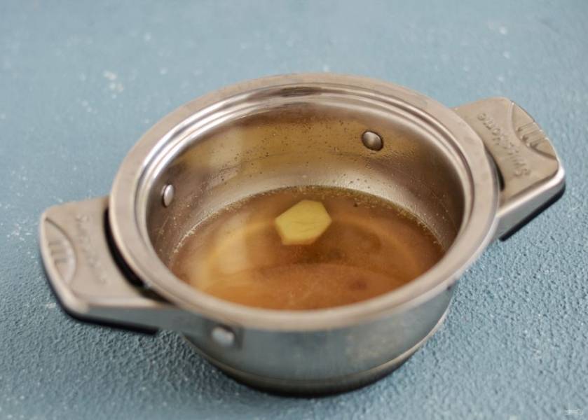 В кастрюле с горячей водой растворите бульонный кубик. Добавьте ломтик имбиря, чеснок и соевый соус, проварите бульон 5-10 минут. 