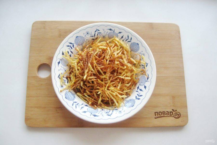 Подсолнечное масло налейте в кастрюлю с толстым дном или такую же сковороду. Хорошо нагрейте масло. Небольшими порциями отправляйте картофель в кипящее масло. Сразу будет очень сильное кипение, но через несколько минут пена спадет и дальше картошка будет равномерно обжариваться в масле. На каждую порцию уйдет примерно 6-7 минут на огне чуть меньше среднего. Готовую соломку выложите на бумажное полотенце для удаления лишнего жира.