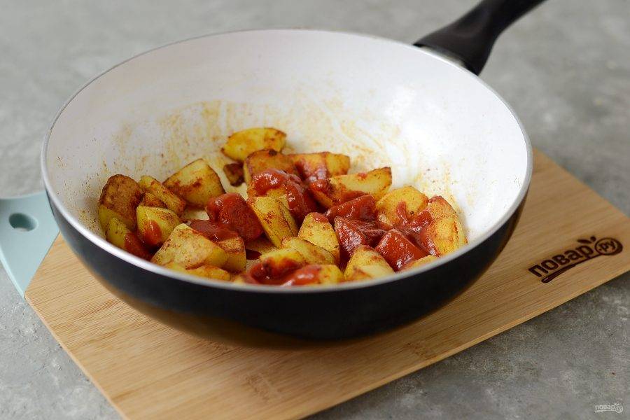 Увеличьте огонь, добавьте разведенную томатную пасту. Перемешайте и жарьте картофель 3-4 минуты.