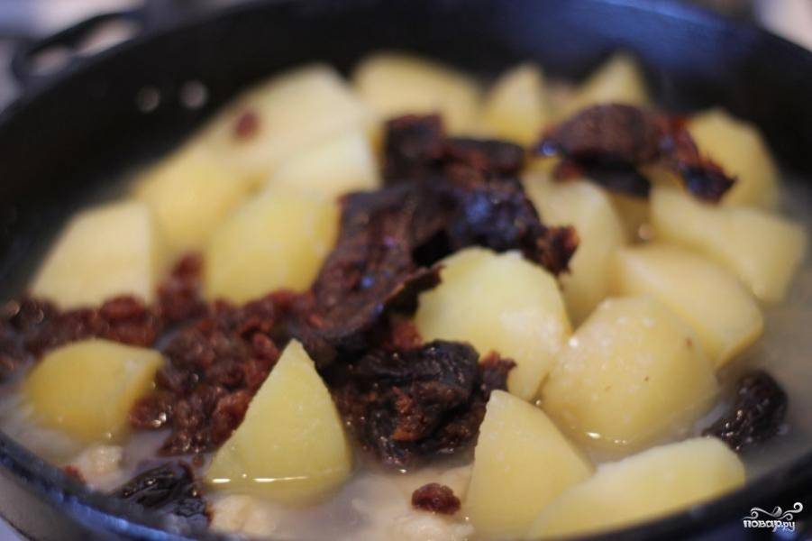 За 10 минут до готовности к картофелю добавить чернослив и изюм. Через 5 минут добавить сахар и соль.