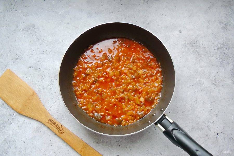 Налейте 100-150 мл. воды, перемешайте. Накройте сковороду крышкой и тушите лук, огурец и томатную пасту 10-12 минут на огне чуть ниже среднего.