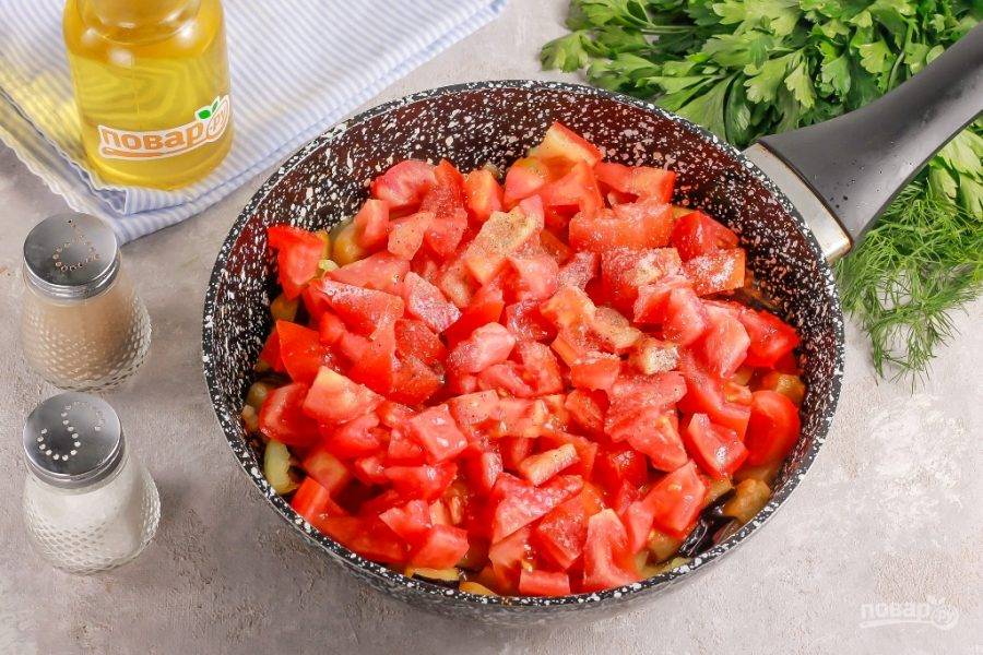 В это время промойте помидоры и вырежьте из них зеленые сердцевинки. Нарежьте сердними или мелкими кубиками и добавьте в емкость. Всыпьте соль и молотый черный перец. Потушите все примерно 5 минут.