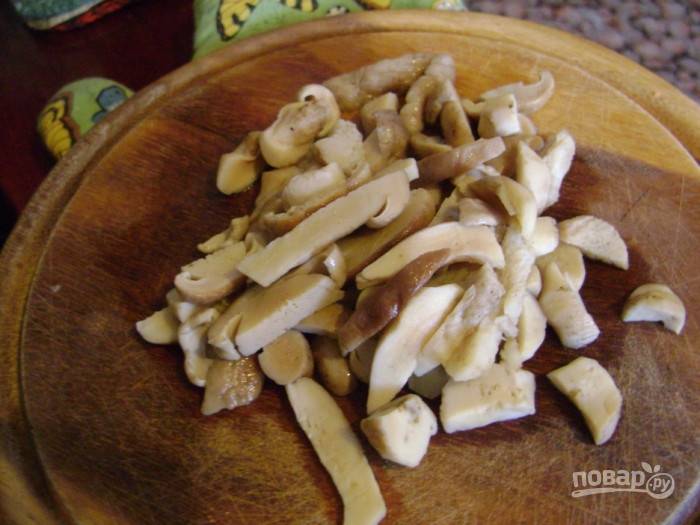 Готовые грибы достаньте из бульона, а затем нарежьте.