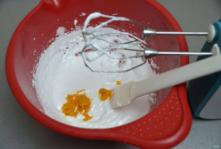 Взбивайте яичный белок с сахаром  до стойких пиков, добавьте апельсиновую цедру и снова взбейте.