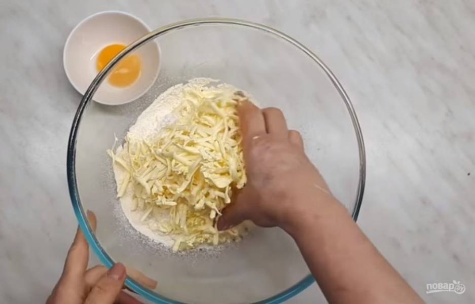 1. Приготовьте тесто: просеянную муку смешайте с солью, холодным, натертым на крупной терке маргарином. Протрите руками до состояния крошки. Добавьте желток, перемешайте. 