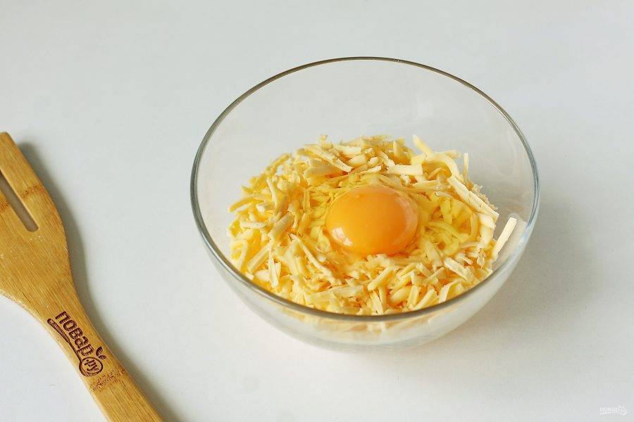 Добавьте к сыру яйцо.