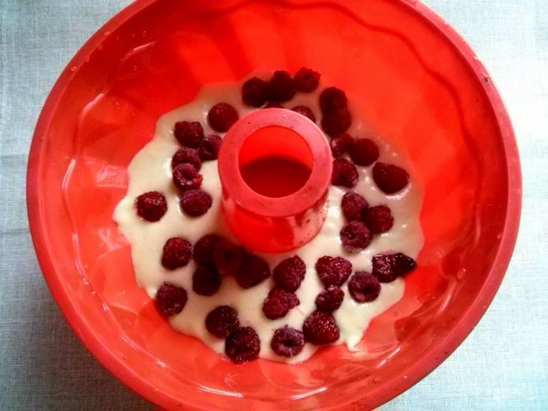 Разогрейте духовку до 180 градусов. Силиконовую форму смочите водой. Вылейте в форму половину теста, выложите ягоды.