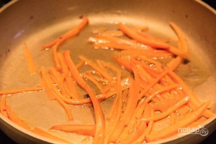 Тем временем нарезаем тонкой соломкой морковь и обжариваем ее на сковороде на оливковом масле до золотистой корочки. 