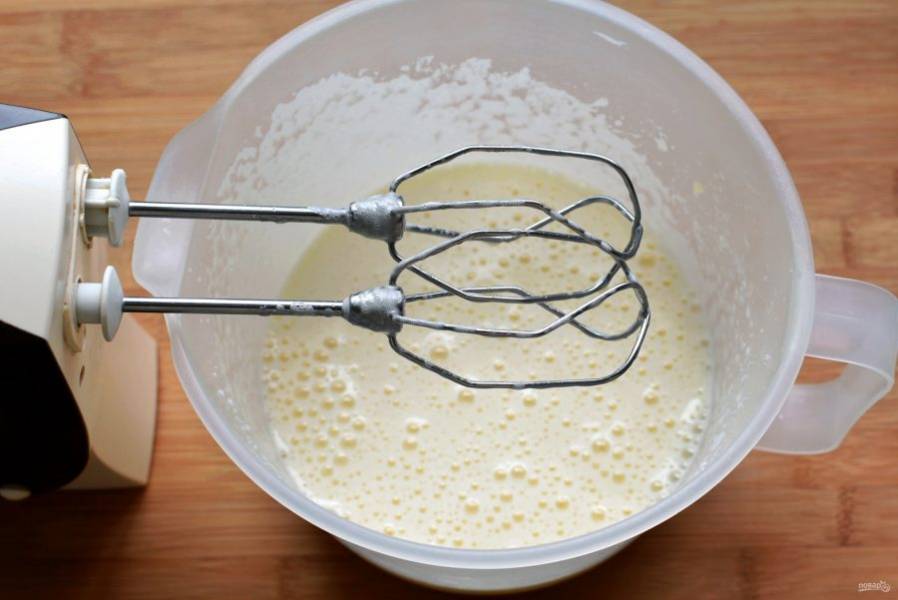 Взбейте яйца с тремя ложками простого сахара и пакетиком ванильного до образования плотной пышной пены. Взбивайте не менее 2-3 минут.