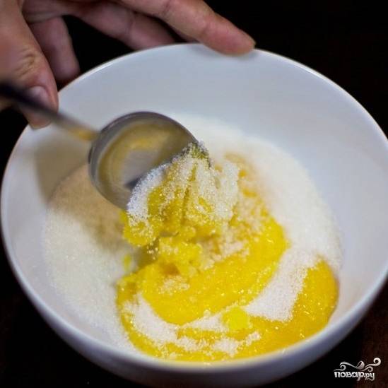 Половину сахара добавляем в желтки, при помощи чайной ложки хорошенько перемешиваем.