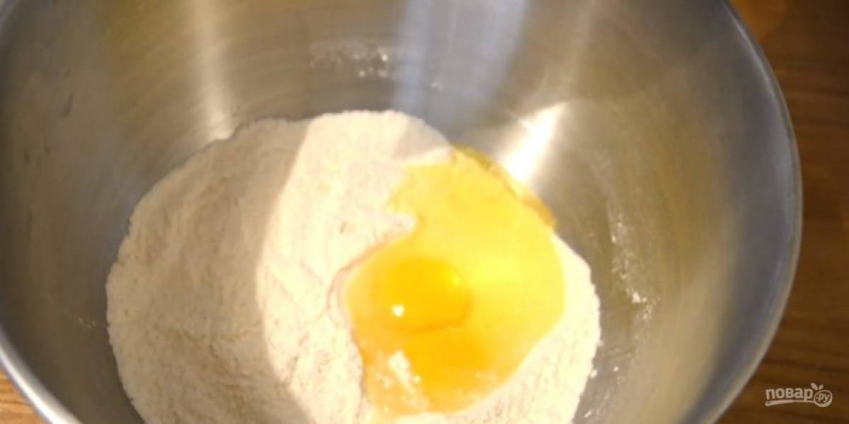 2. Поставьте на небольшой огонь, накройте крышкой и дайте жидкости испариться. Приготовьте тесто: просеянную муку смешайте с разрыхлителем, солью и сахаром. Добавьте яйца и мягкое сливочное масло.