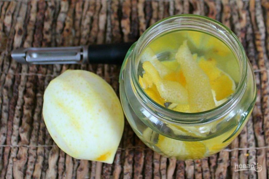 Лимон обдайте кипятком. Снимите тонкий верхний слой шкурки и добавьте в воду.