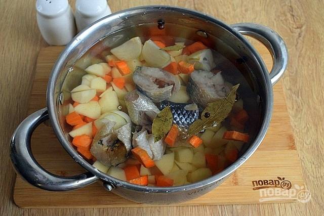 Луковицу разрежьте на 4 части, морковь и картофель нарежьте мелкими кубиками. Заложите овощи и специи в кастрюлю с водой. Доведите до кипения и варите на минимальном огне в течение 15 минут. Выньте специи и луковицу. Добавьте филе рыбы, нарезанное на порционные кусочки. Доведите до кипения, снимите пену. Варите на минимальном огне  в течение 20 минут.
