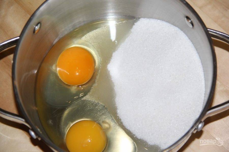 В кастрюлю  вбейте  2 яйца, всыпьте 200 грамм сахара, добавьте мед.
Поставьте на водяную баню греться все ингредиенты, слегка помешивая венчиком.  
