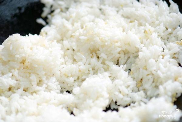 5. Положить в сковороду рис и тщательно перемешивать, чтобы рис не начал слипаться, а хорошо соединился с чесноком.