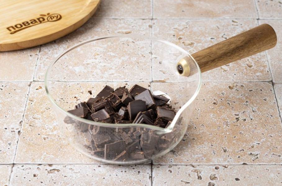 Шоколад крупно порубите и растопите в сотейнике до жидкой консистенции.