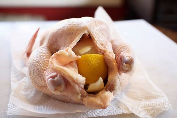 5. Ароматной смесью смажьте птичку как следует внутри, после поместите туда лук, чеснок и лимон. Обмажьте щедро и сверху. 
