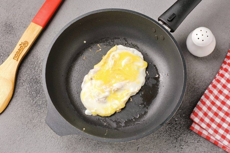 Разбейте яйцо, посолите и быстрыми движениями, при помощи лопатки, перемешайте его придавая ему форму, подходящую по размеру двух кусков хлеба.