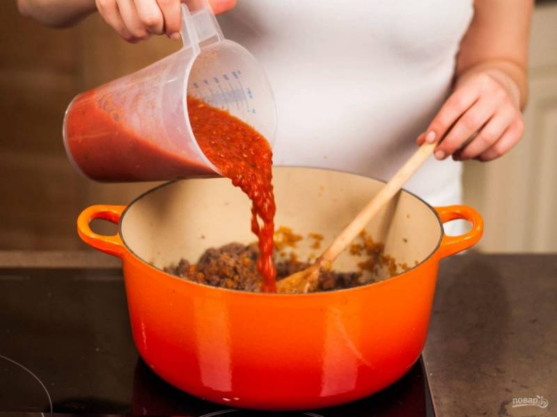 К фаршу отправьте томатный морс, приправьте солью, перцем и орегано. Тушите без крышки на среднем огне примерно 15 - 20 минут, периодически помешивая.