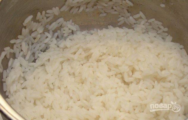В кастрюльку налейте чистую питьевую воду, доведите ее до кипения. Промойте рис и всыпьте его в кастрюлю с кипящей водой. Отварите рис до полуготовности, слейте воду. 