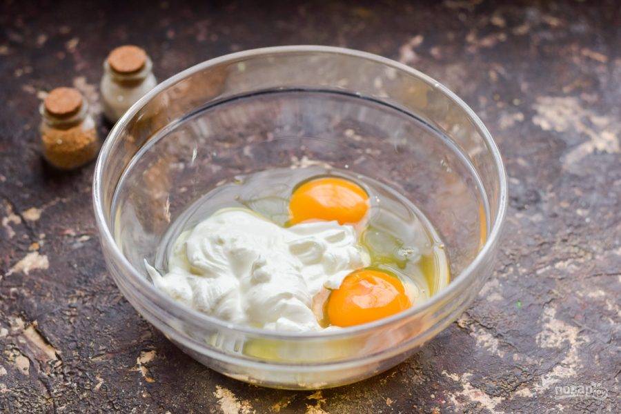В миску вбейте несколько куриных яиц, добавьте сметану.