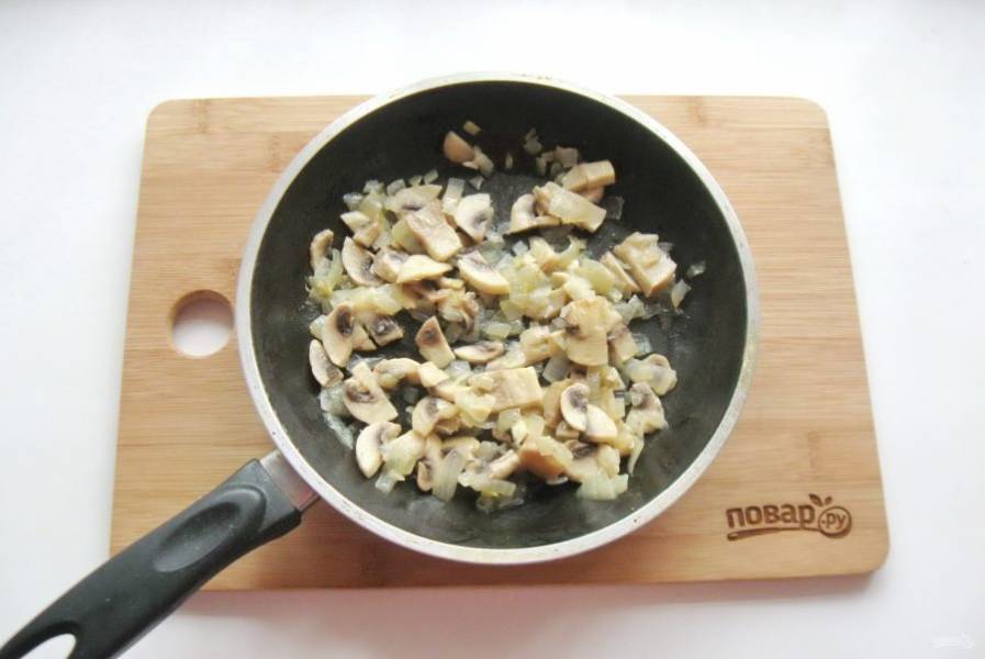 Налейте рафинированное подсолнечное масло и тушите грибы с луком до готовности, периодически перемешивая.