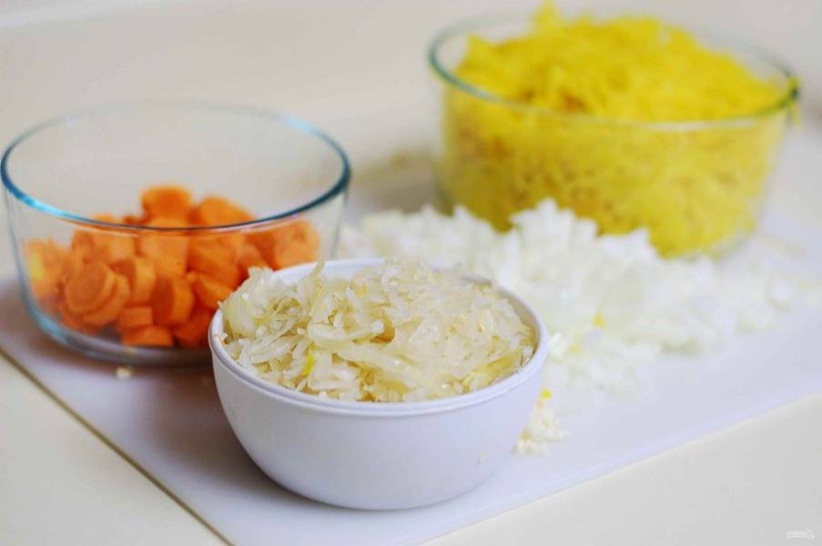 2. Затем с кастрюлю добавьте измельчённый лук и чеснок. Обжарьте всё вместе 2 минуты. В это же время морковь нарежьте кружками, а свеклу натрите на большой тёрке.