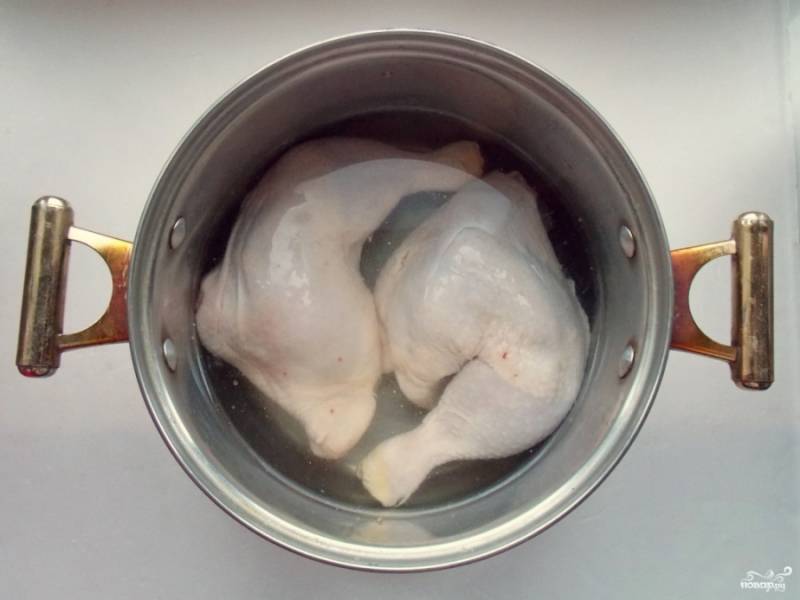 Куриные окорочка промойте, выложите в кастрюлю и поставьте вариться. Варите на среднем огне, периодически снимая пленку, чтобы бульон был прозрачным. 