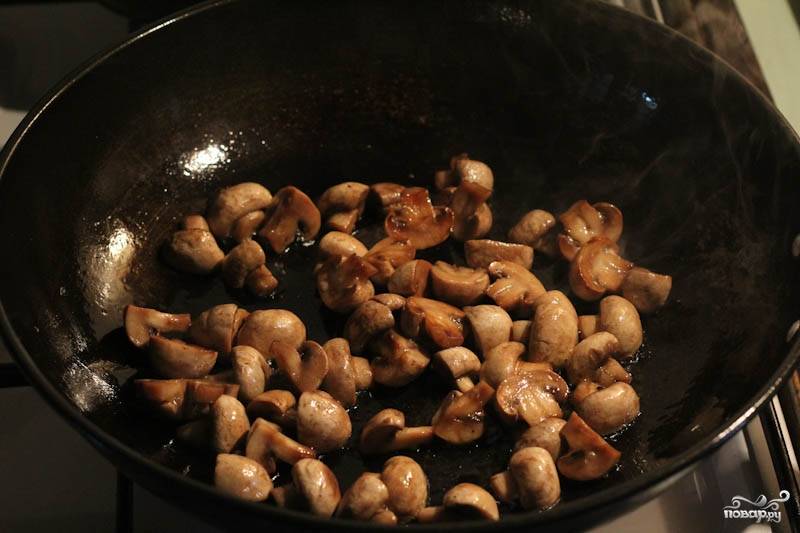 Тем временем приготовьте соус из сметаны и грибов. Грибы почистите и крупно порежьте. 
Обжарьте их на сковороде. Обжаренные грибы добавьте к мясу.