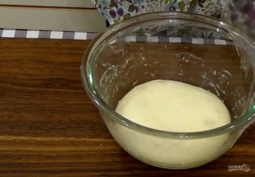 2. Добавьте воду и замесите эластичное тесто (месить нужно не менее пяти минут). Обкатайте тесто в растительном масле, поместите в миску, наройте пищевой пленкой и оставьте при комнатной температуре на 40 минут. 