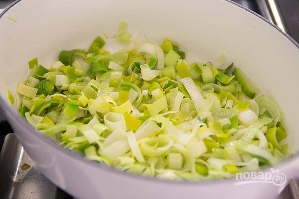 В сковороде или в той же кастрюле, в которой будете готовить суп, растапливаем на среднем огне сливочное масло и обжариваем лук до мягкости. 