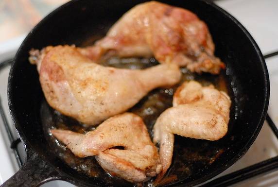 Затем ставим сковороду в разогретую до 230 градусов духовку и запекаем пол часа, в середине приготовления курицу необходимо перевернуть на другую сторону. 