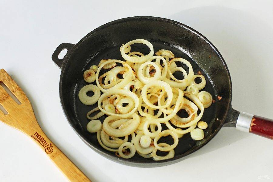 На отдельной сковороде обжарьте нарезанный кольцами лук.