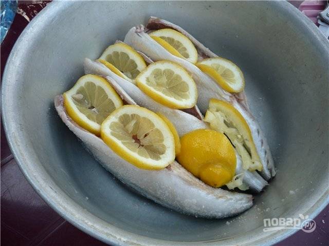 4. Нарежьте лимон тонкими ломтиками, разложите его вокруг и внутри рыбки. Оставьте мариноваться на 1.5-2 часа. 