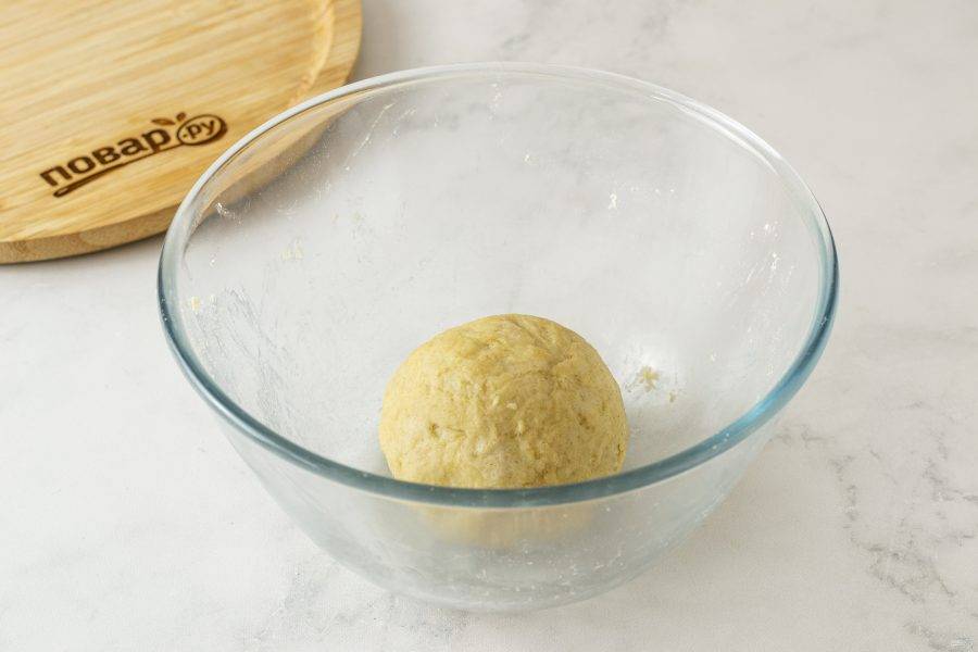 По ложке начните добавлять в миску холодную воду. Замесите однородное эластичное тесто. Скатайте его в шар, заверните в пленку и уберите в холодильник на 30 минут.
