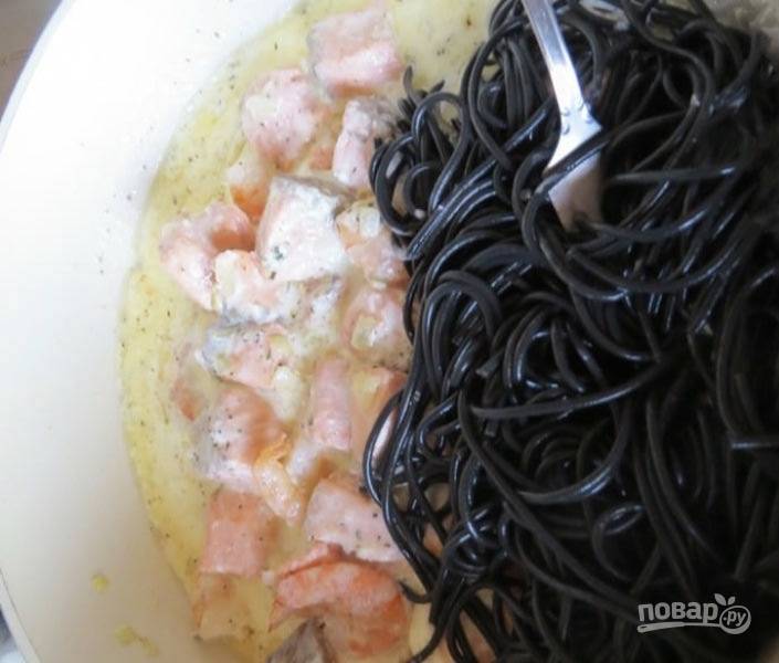 Спагетти добавьте в сковороду к морепродуктам в сливочном соусе. Аккуратно все перемешайте.