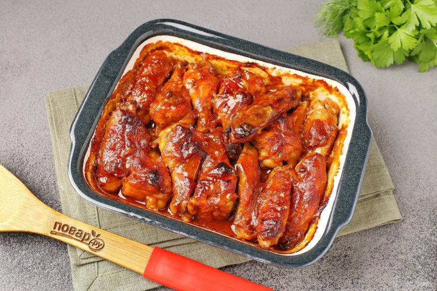 Куриные крылышки в томатно-соевом маринаде готовы. Переложите их на тарелку для подачи и полейте сверху оставшимся в форме соусом.