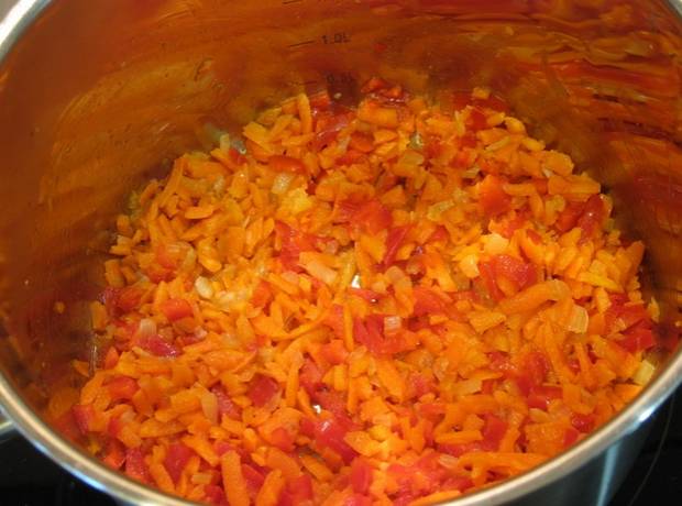 Разогреваем кастрюлю с растительным маслом, добавляем в нее измельченные овощи: лук, морковь и перец. Обжариваем пару минут.