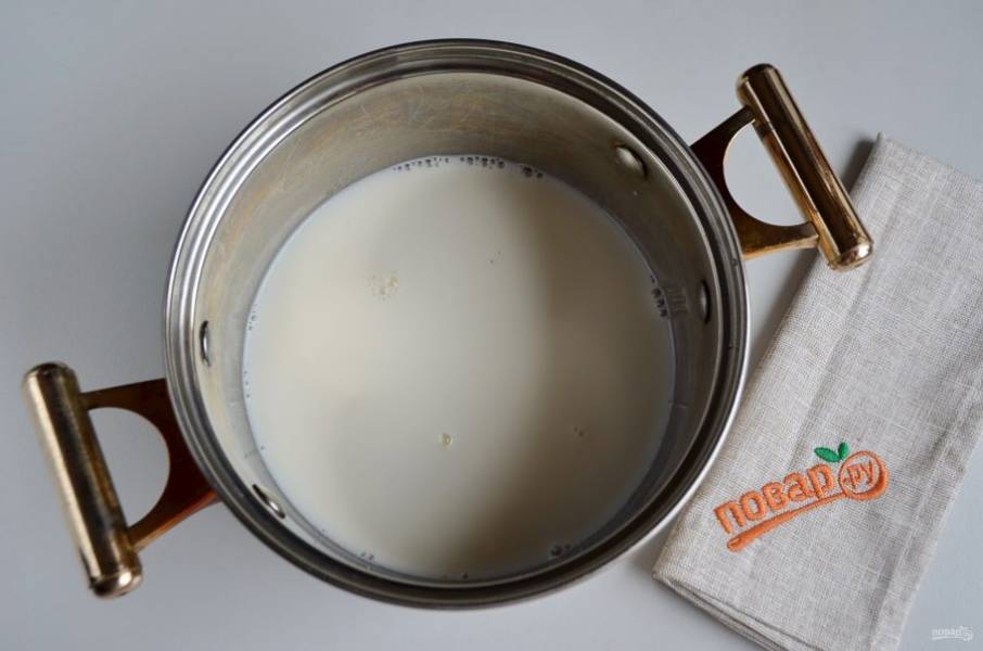 Пока первый корж в духовке, можно сделать крем. Влейте в кастрюлю 2 стакана молока, доведите до кипения, всыпьте сахар и ванильный сахар. Перемешайте и снова доведите до кипения.