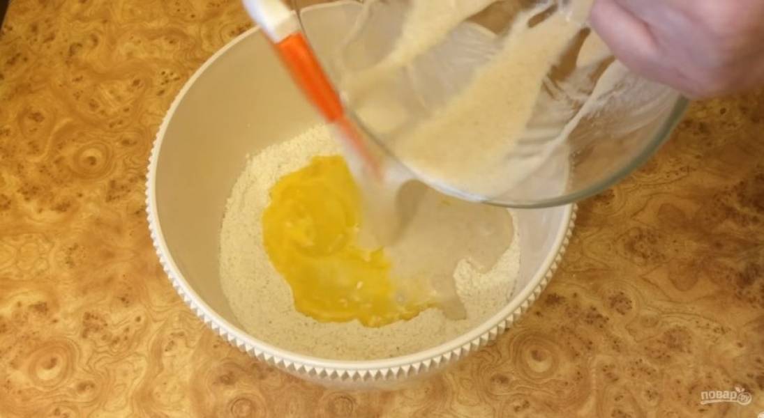 2. Добавьте воду комнатной температуры и хорошо перемешайте. В миску выложите просеянную муку, сахар и соль. Сделайте небольшое углубление и выложите туда  яйцо. Взболтайте яйцо вилкой и добавьте опару. 