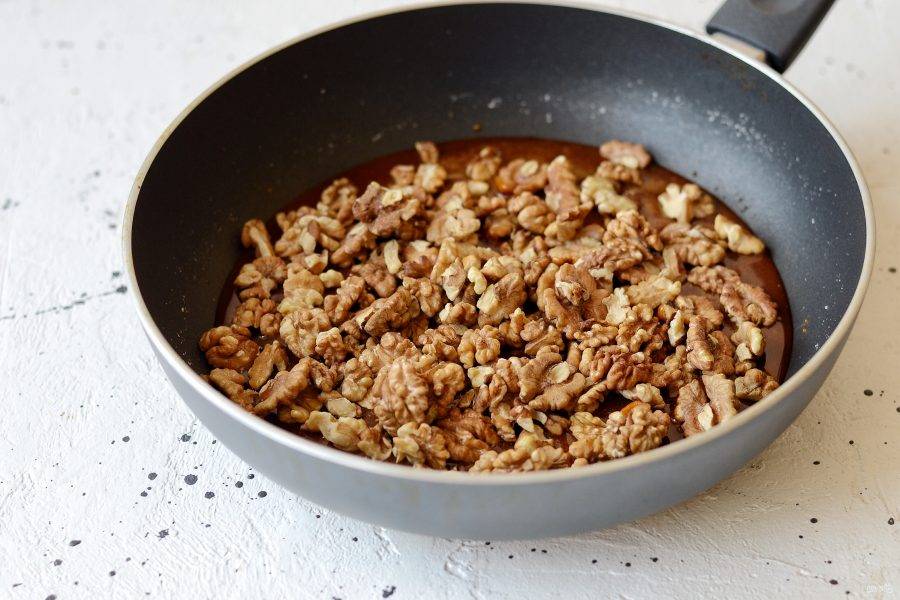 Добавьте грецкие орехи в карамель. Перемешайте. Нагревайте карамель до тех пор, пока орехи полностью не будут ей покрыты. 