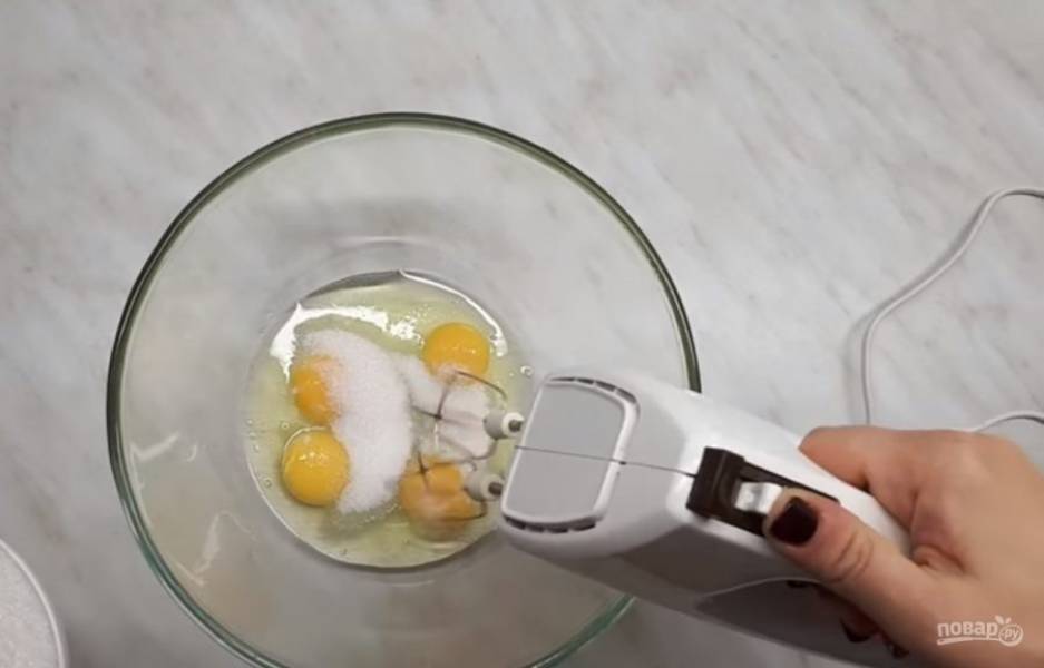 1. Подготовьте форму диаметром 26 см, яйца взбейте миксером со щепоткой соль, постепенно добавляя сахар. Взбейте яйца до пышной светлой массы, добавьте растопленное и слегка остывшее сливочное масло, Бейлис. 